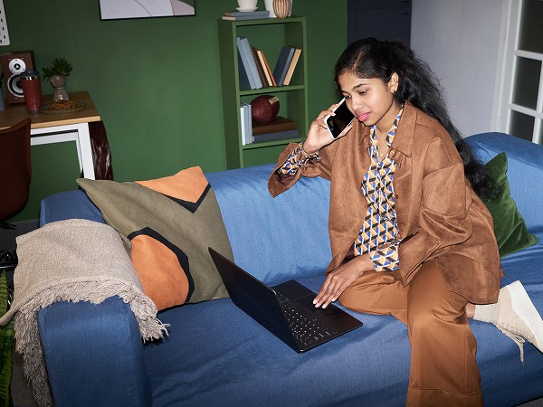 A lady with a laptop sitting in an office building.