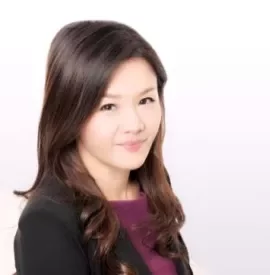 Person smiling in professional attire against a light background.