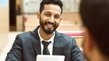 Person smiling and talking in a professional setting.