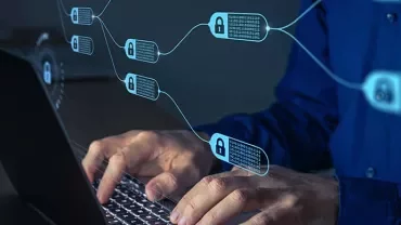 Person typing on laptop with blockchain symbols