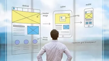 Person looking at website wireframe sketches on glass.