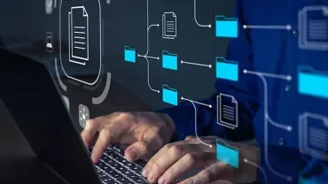 Person typing on a laptop with a digital overlay of file icons and network lines.