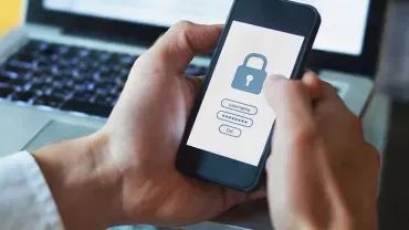 Person holding smartphone with lock screen for login.