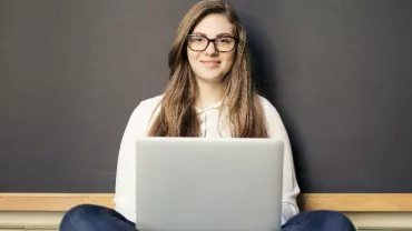 Woman-Smiling-While-Using-a-Laptop