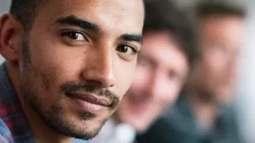 Person looking at the camera with others in the background.