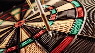 Close-up of darts on a colorful dartboard.