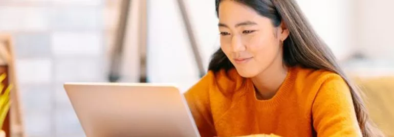 Woman-Smiling-While-Using-a-Laptop