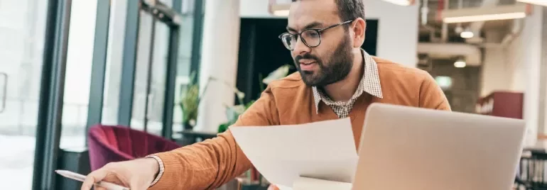 One male professional going through documents at a work desk