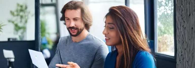 A man and woman review a document, discussing strategies for retaining top talent through career growth opportunities.