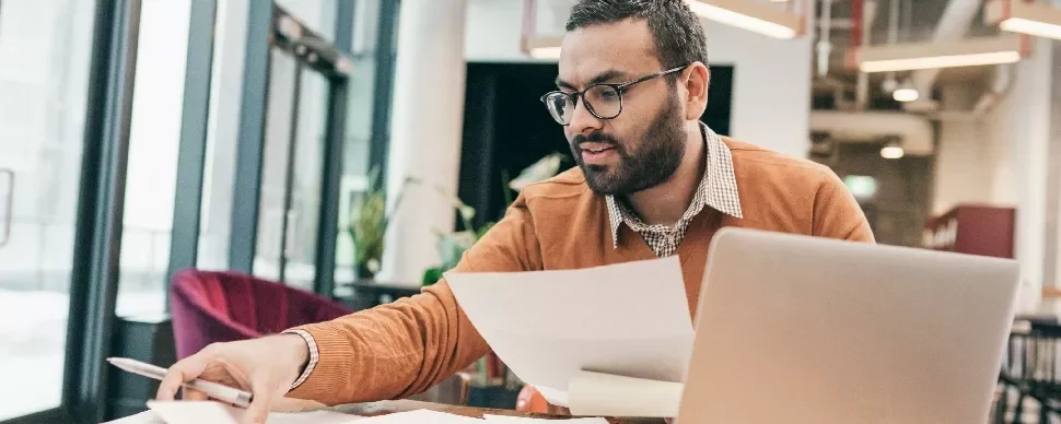 One male professional going through documents at a work desk