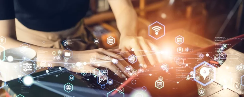 Person typing on a laptop with digital network icons floating around.