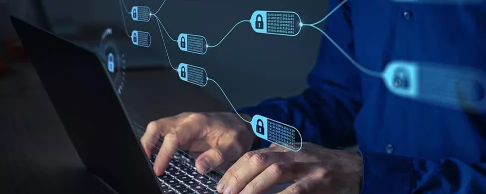 Person typing on laptop with blockchain symbols