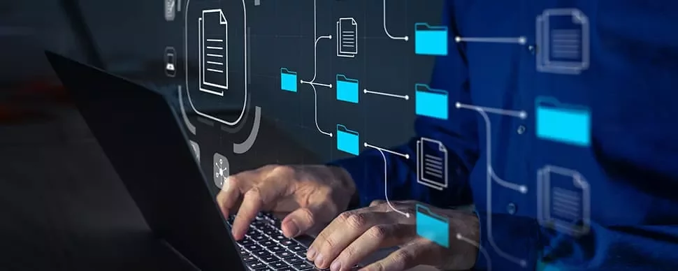 Person typing on a laptop with a digital overlay of file icons and network lines.