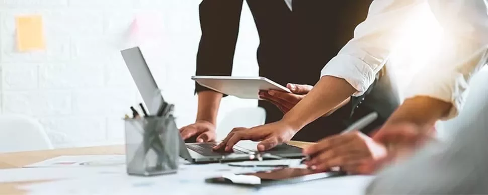 People collaborating with laptops and tablets in a modern office.
