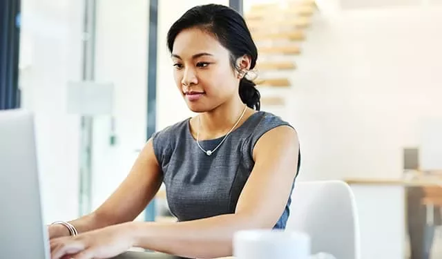 Person working at a laptop in a modern office.