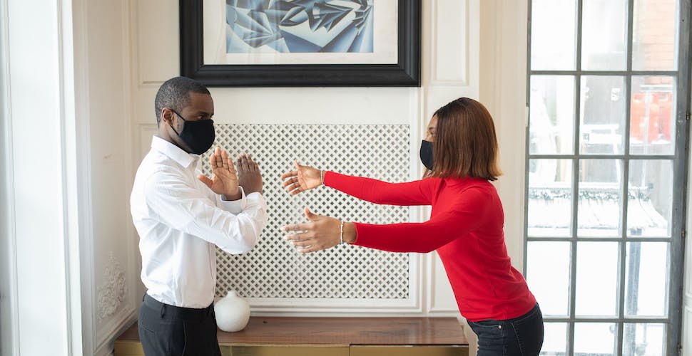 Boss in fabric mask showing no gesture against partner. Photo by Monstera Production via Pexels.